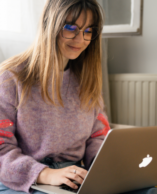 free-lance web designer souriante travaillant sur son ordinateur portable